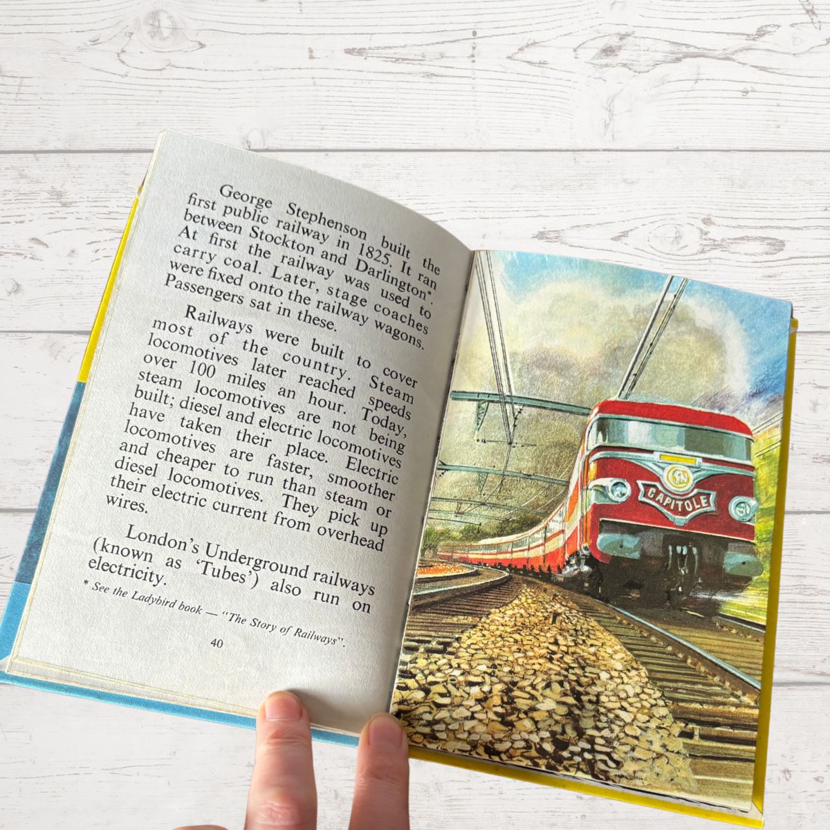 Open book with a train illustration on a wooden surface