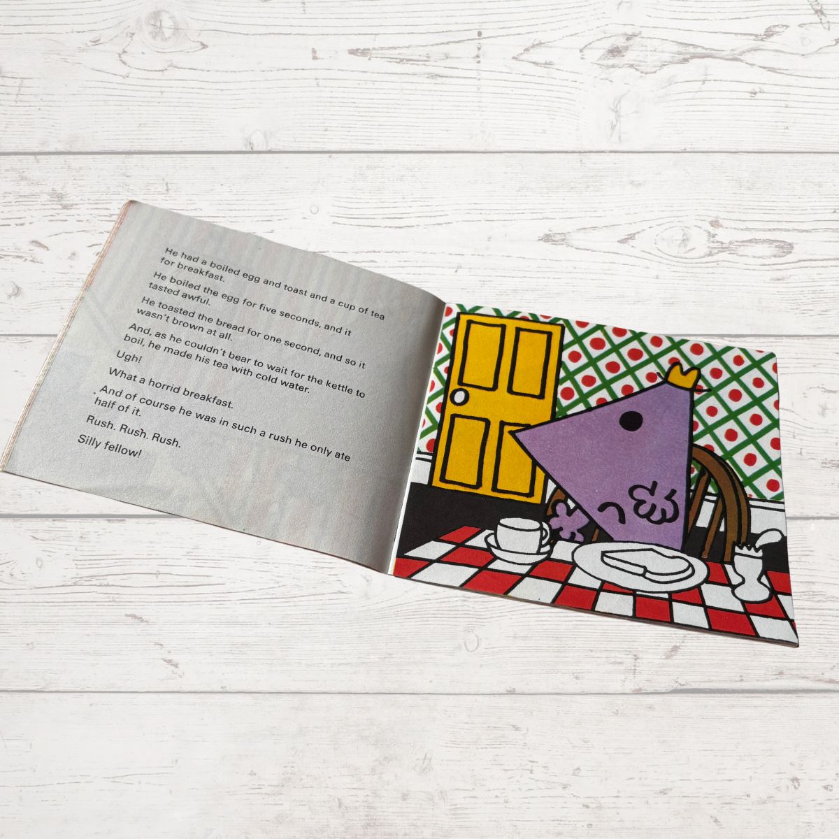 Open book with colorful illustration on a wooden surface