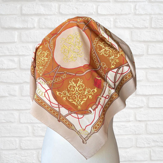 Decorative scarf with intricate patterns on a white brick wall background