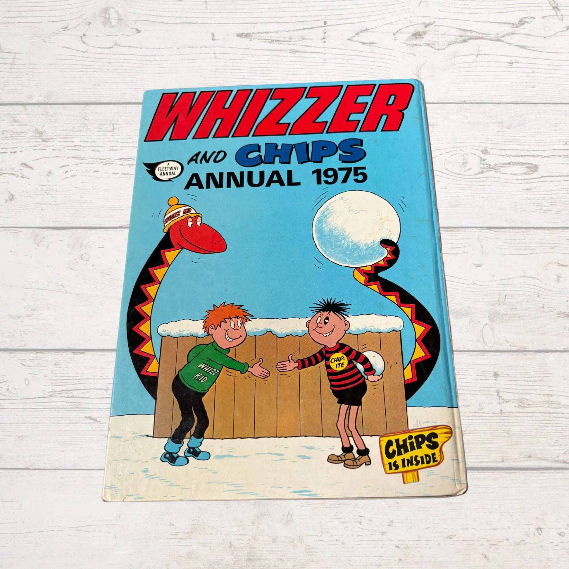 Vintage 'Whizzer and Chips Annual 1975' on a wooden surface