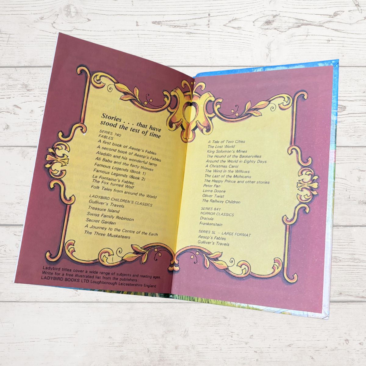 Open book with decorative cover on a wooden surface