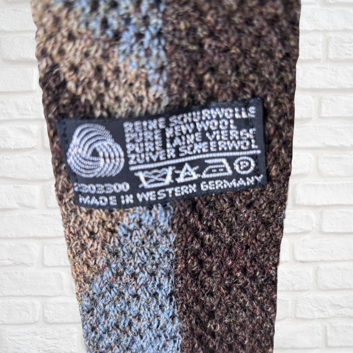 Textile product with a label on a white brick wall background