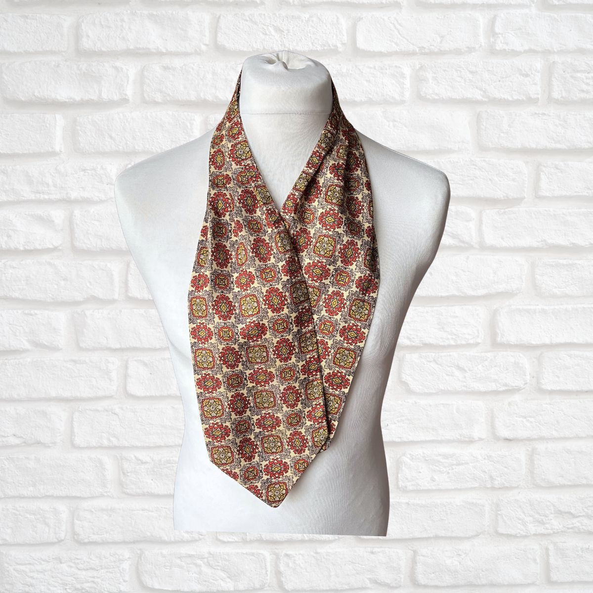 Patterned necktie on a mannequin against a white brick wall background