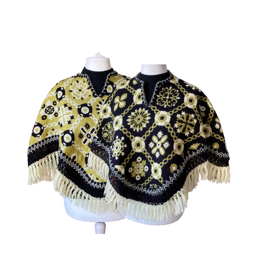 Two images of a reversible 70s fringed poncho . One side is black and green patterned and the other green and black patterned.