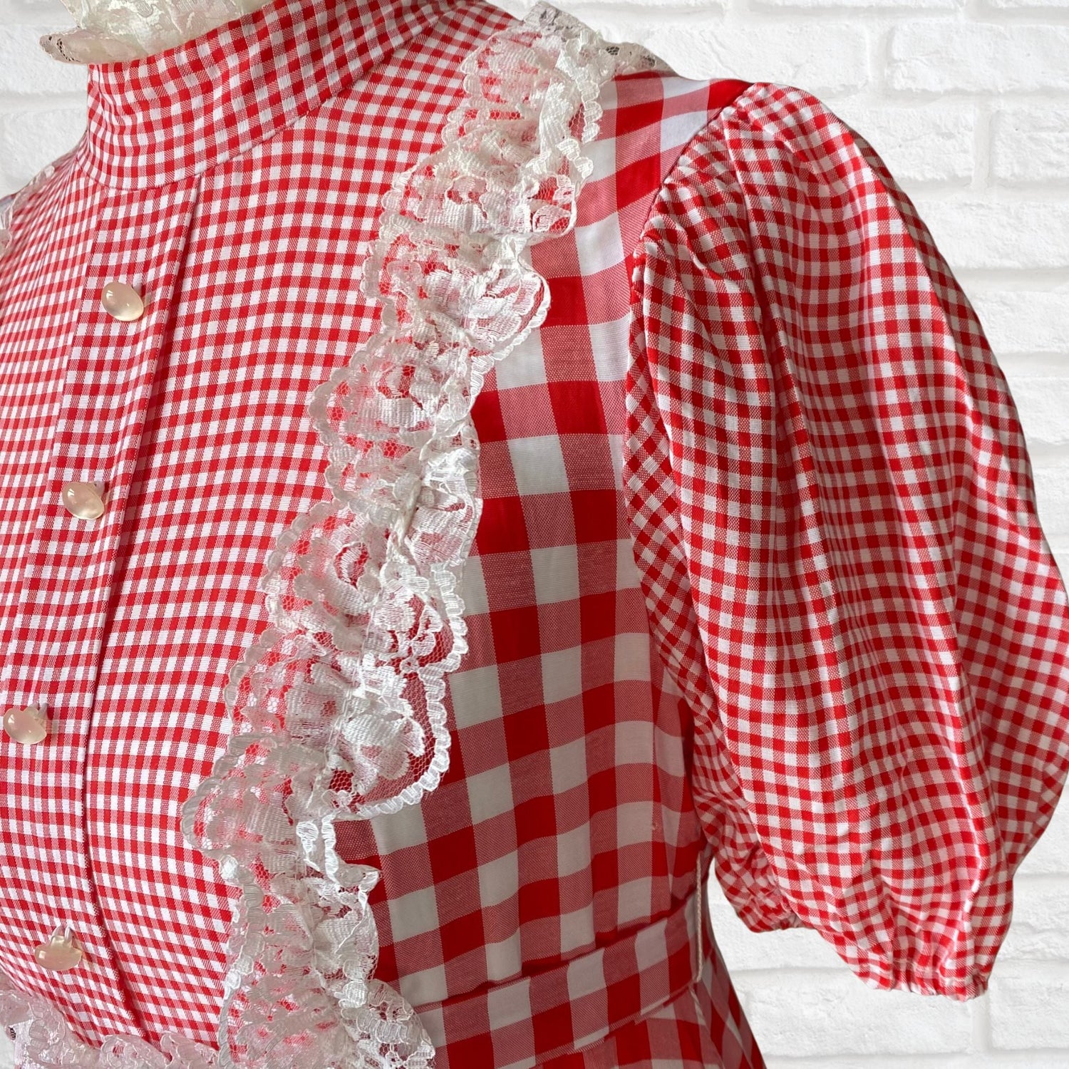 A red and white gingham 70s maxi dress with pearly buttons, a high lace trimmed neck and white lace of the bodice 