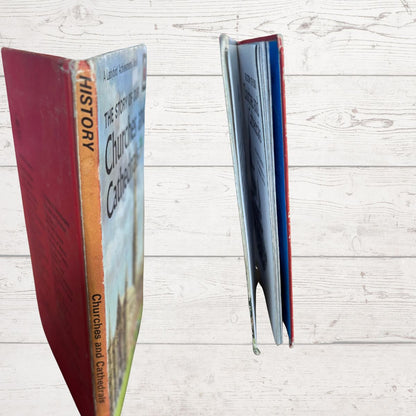 A hardcover book titled "The Story of Our Churches and Cathedrals" shown standing upright with its front cover visible on the left and pages fanned out on the right, set against a light wood plank background.