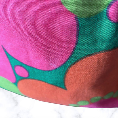 A close-up of a colourful patterned bag  shown against a small white marble surface.