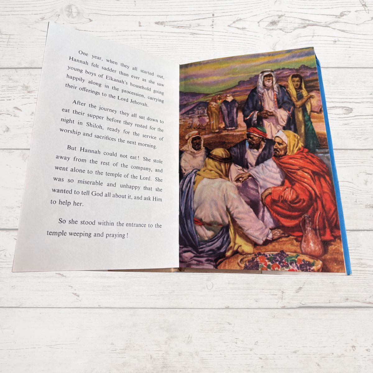 Open book with text and a colorful illustration on a wooden surface