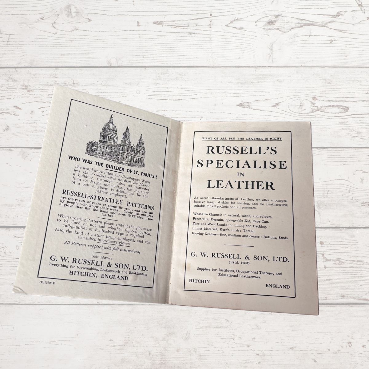 Open book with text and a building illustration on a wooden surface
