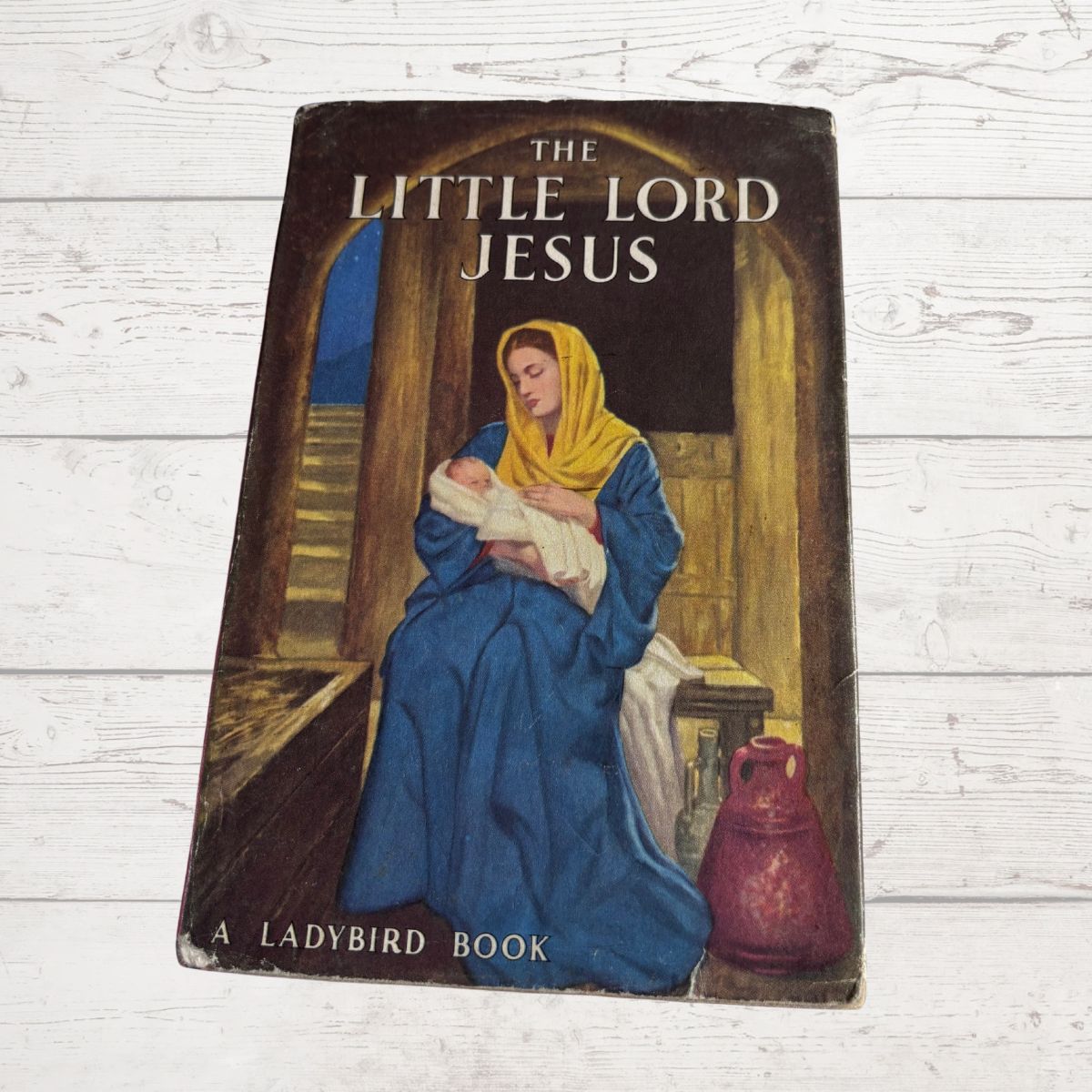 Vintage book titled 'The Little Lord Jesus' by Ladybird on a wooden surface