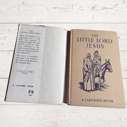 Open book titled 'The Little Lord Jesus' by Ladybird on a wooden surface