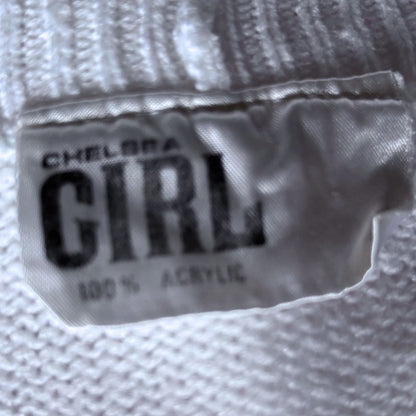Close-up of a white textured fabric tag with black text reading 'CHELSEA GIRL' and '100% ACRYLIC'.