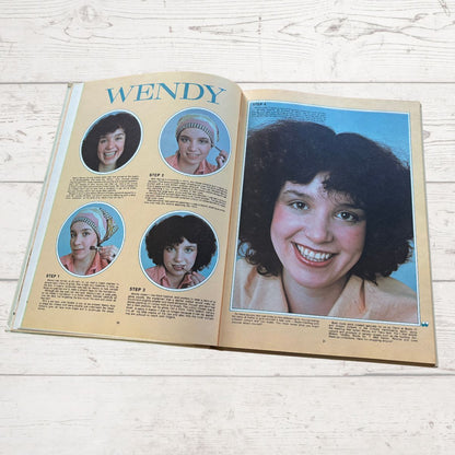 Open book showing a page with a woman's face and step-by-step instructions on a light wooden surface.