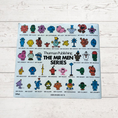 Placemat with colorful Mr Men illustrations on a light wooden surface