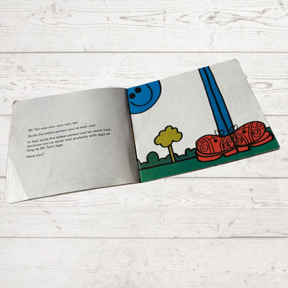 Open book with colorful illustrations on a light wooden surface