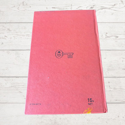Red book with a logo on a light wooden surface