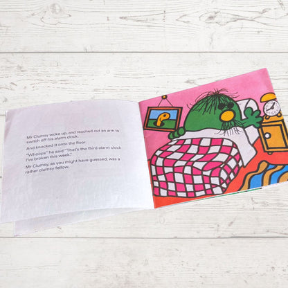 Open book with a colorful illustration of a green character and text on a wooden surface