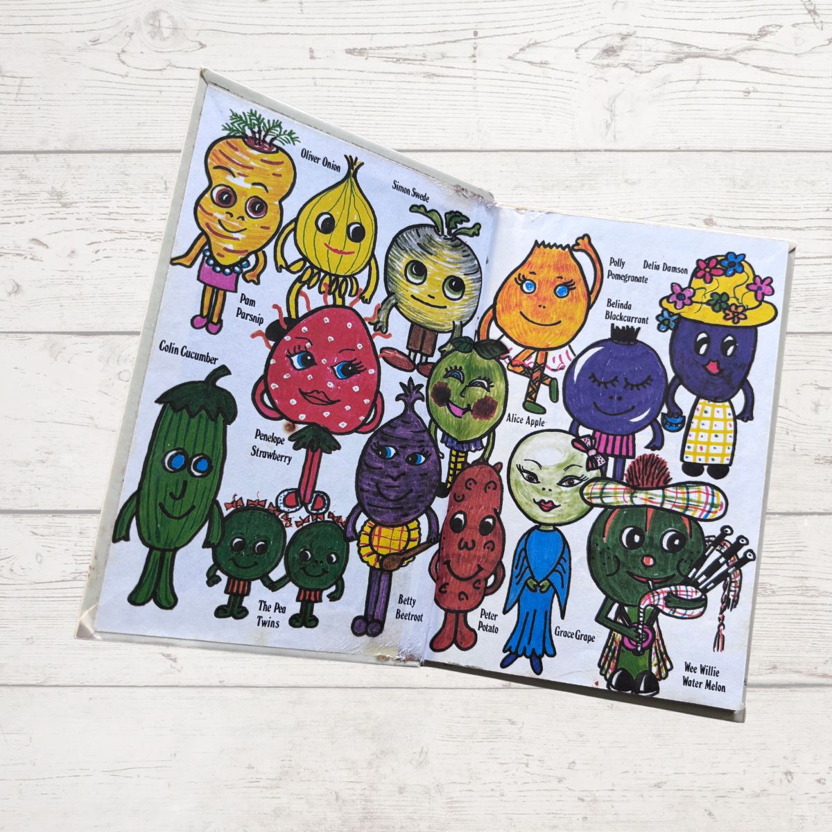 Colorful  cartoon vegetable characters on a white wooden surface