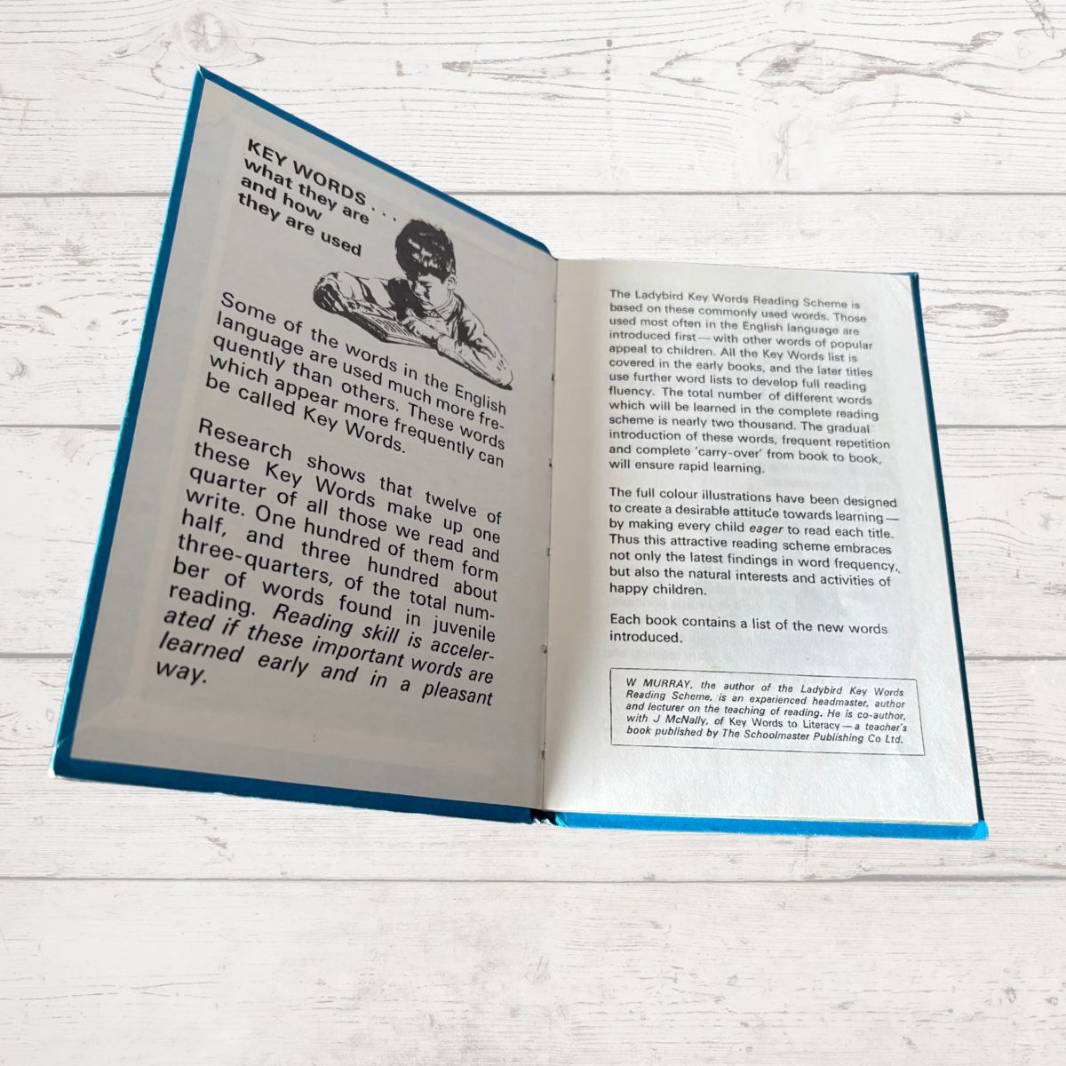 Open book on a wooden surface with text and an illustration of a child.