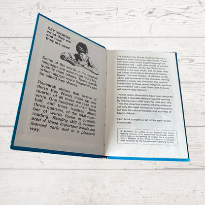 Open book on a wooden surface with text and an illustration of a child.