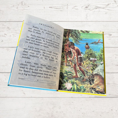 Open book with a historical illustration and text on a wooden surface