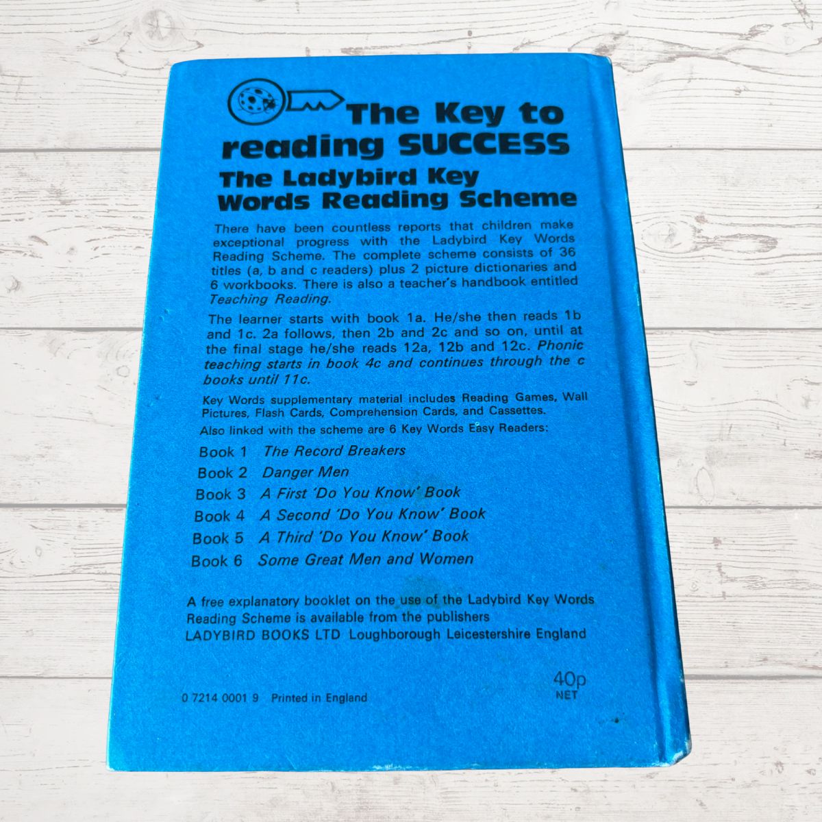 Blue book titled 'The Key to Reading Success' on a light wooden surface