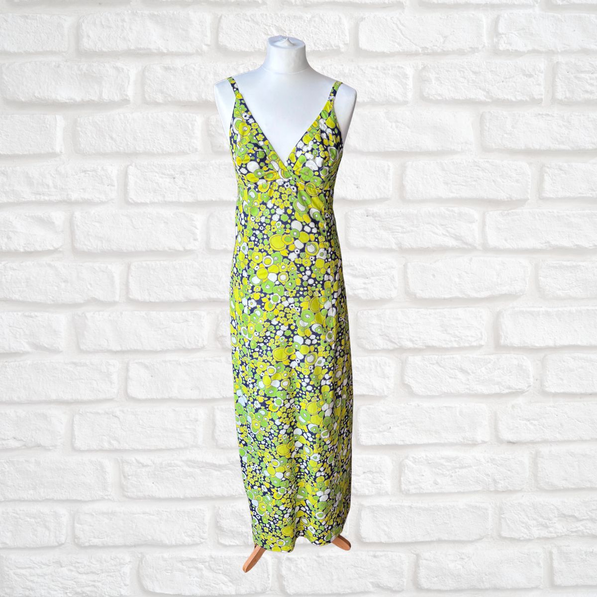 Abstract Floral dress on a mannequin against a white brick wall background