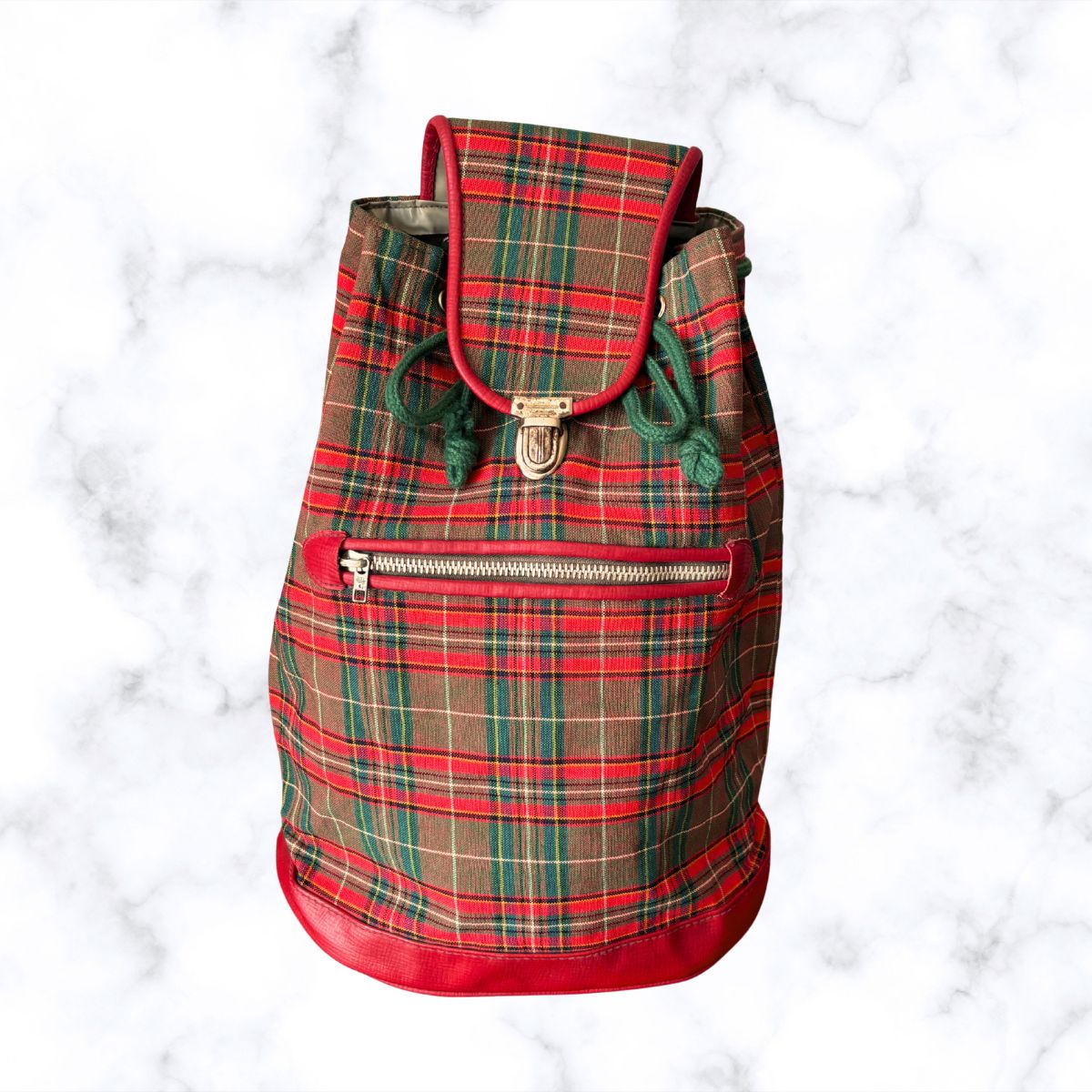 Plaid backpack with red accents on a white marble background