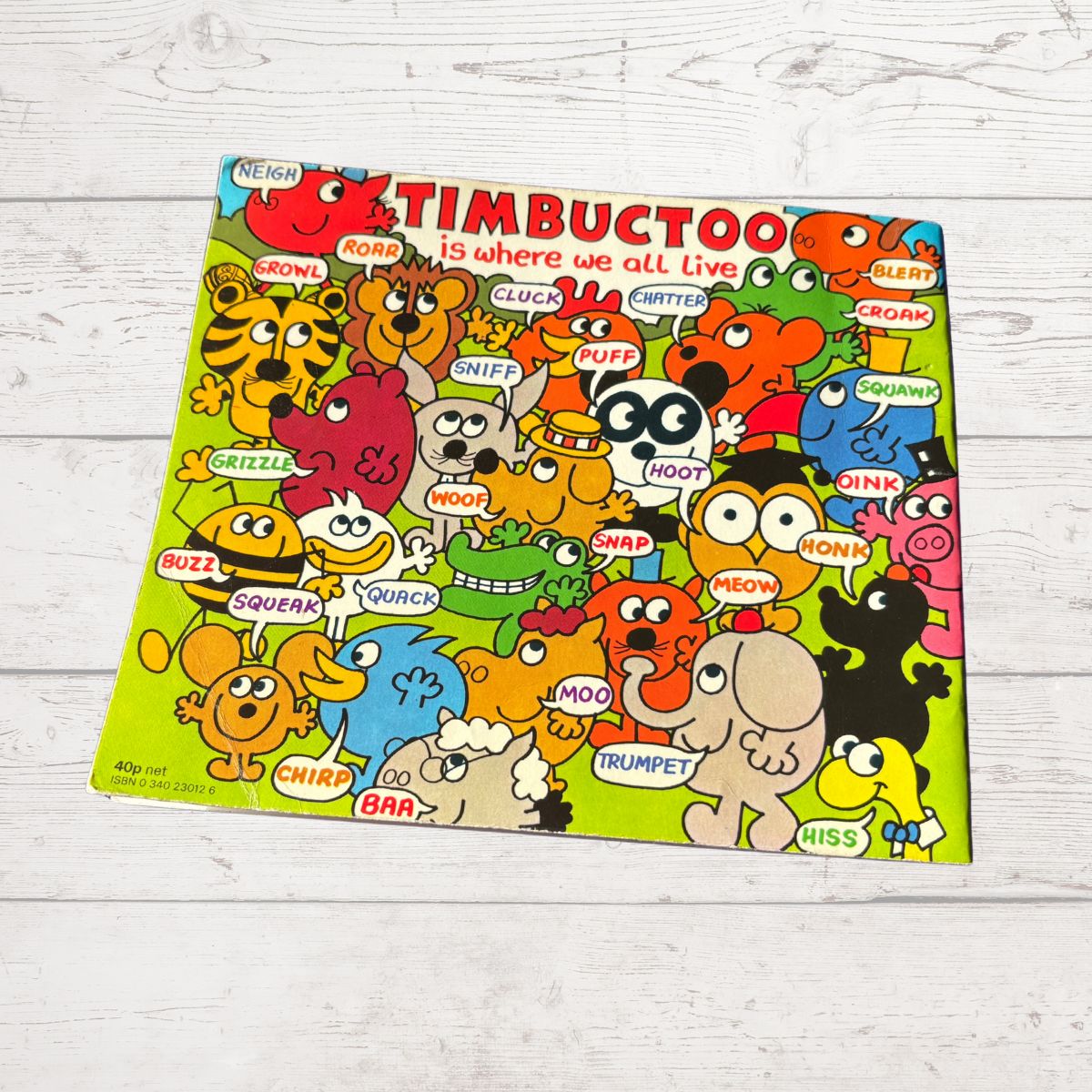 Colorful book cover of 'Timbuctoo' with cartoon animals on a wooden surface