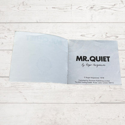 Open book with 'MR. QUIET' title on a wooden surface