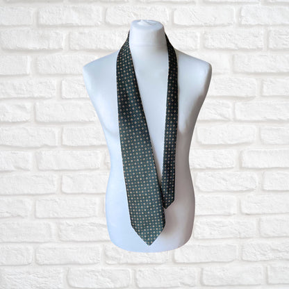 A green, orange and white geometric floral  print vintage 70s tie on a mannequin