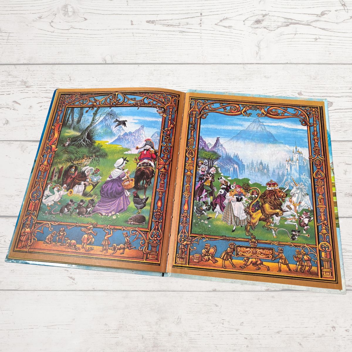 An open vintage children's book displaying two illustrated spread pages with colorful medieval and fantasy scenes, set on a white wooden surface.