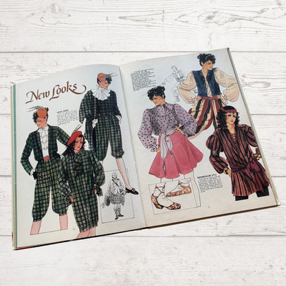 Open book showing vintage fashion illustrations on a wooden surface
