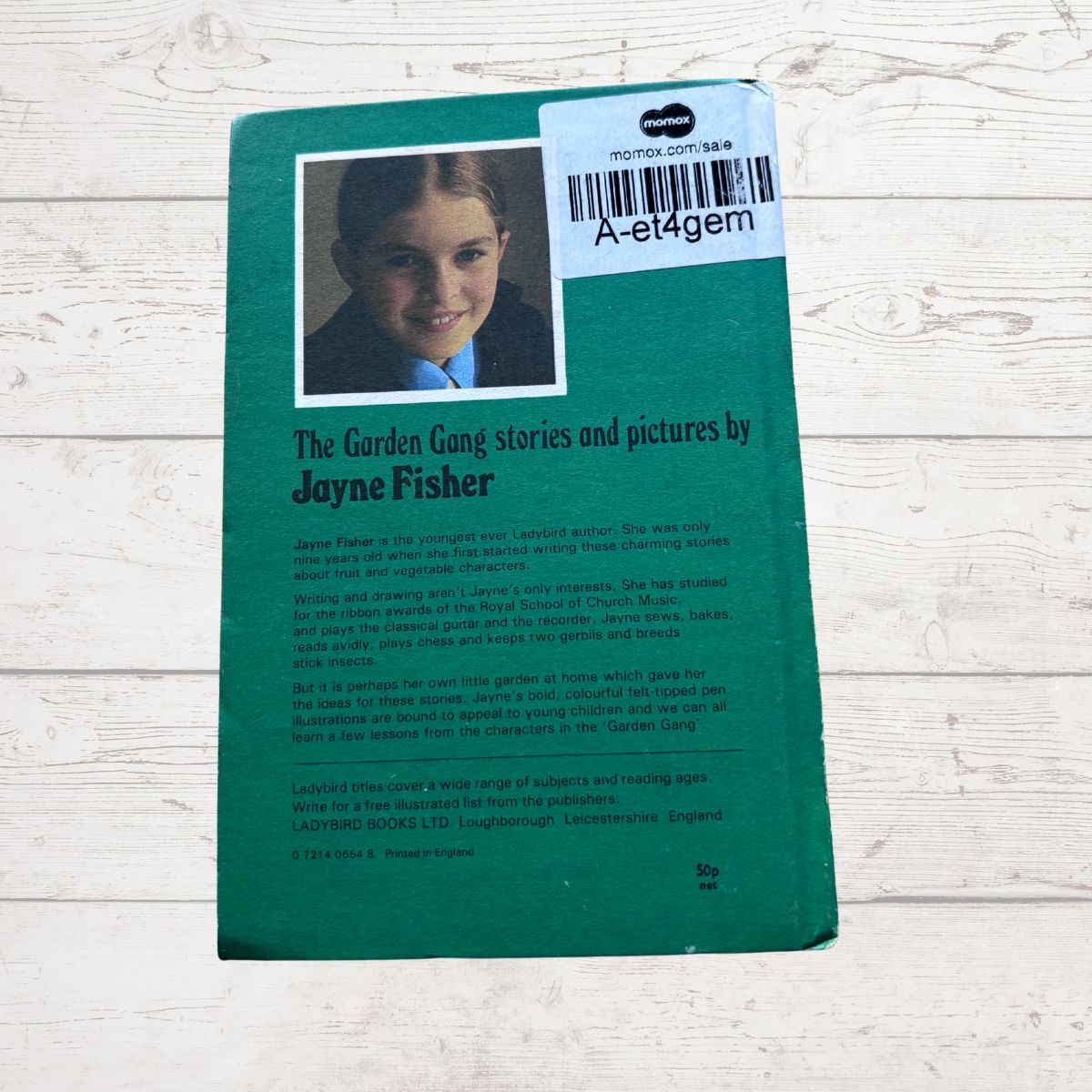 Book cover with a child's photo and text on a wooden surface