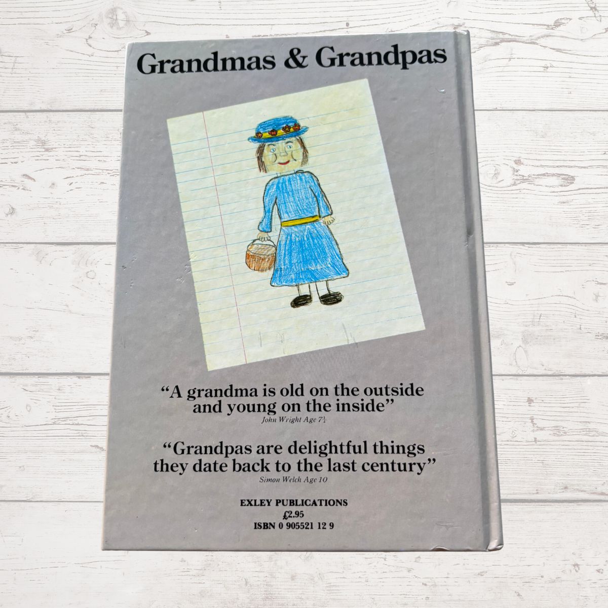 Book titled 'Grandmas & Grandpas' with a drawing of a woman on the cover, on a wooden surface.