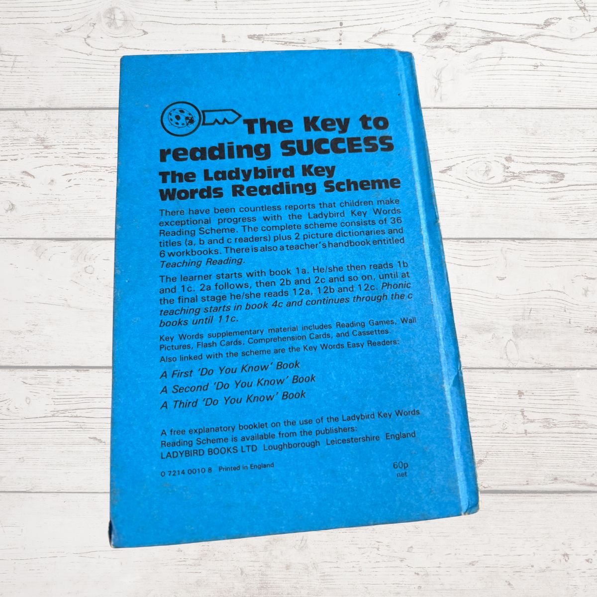 Blue book titled 'The Key to Reading Success' on a wooden surface