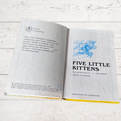 An open copy of the children's book 'Five Little Kittens' by A. J.