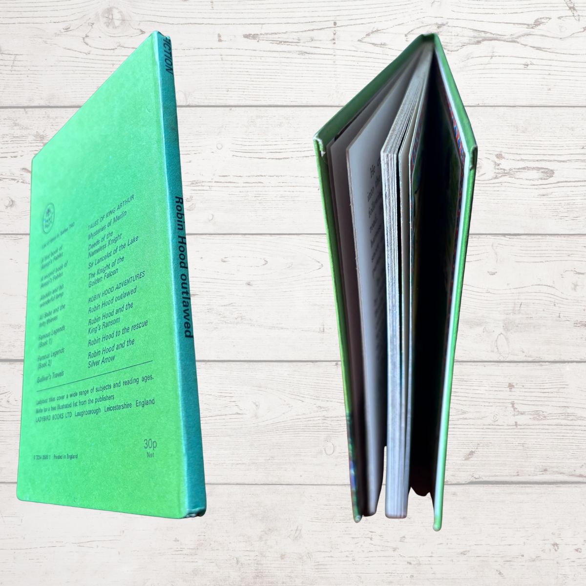 A hardcover book shown from two angles on a light wood plank background: the back cover on the left in bright green with black text, and the open middle spread on the right showing multiple interior pages.