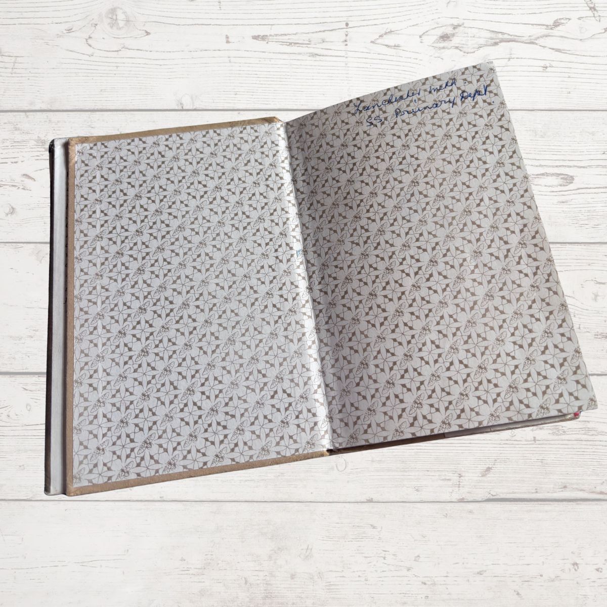 Open book with textured pages on a light wooden surface
