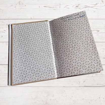 Open book with textured pages on a light wooden surface