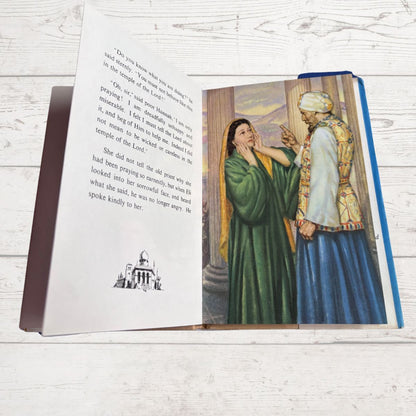 Open book with text and a colorful illustration on a wooden surface
