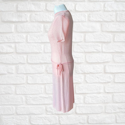 A light pink dress displayed on a mannequin torso against a white brick wall background.
