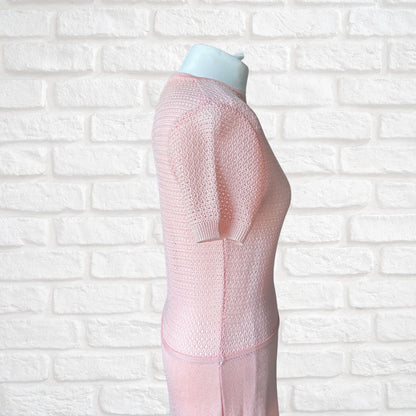 A light pink short-sleeve dress displayed on a white mannequin torso against a white brick wall background.