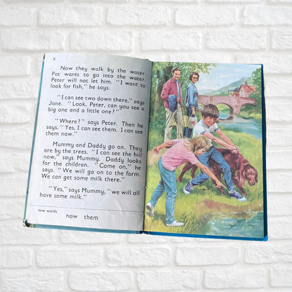 Open book with a colorful illustration on a white brick wall background