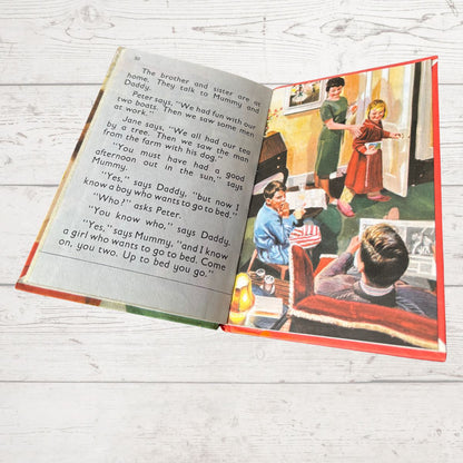 Open book with illustrations of children on a wooden surface