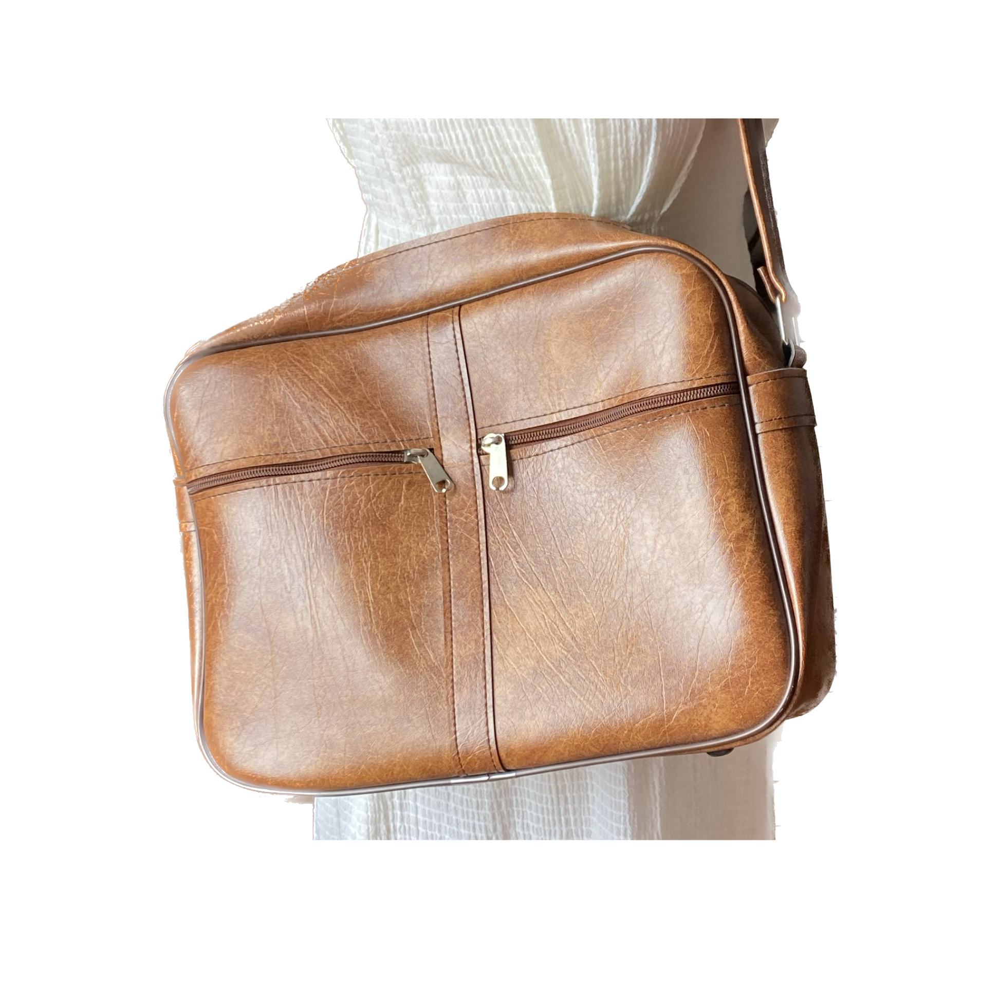 Light brown vinyl zip up bag with shoulder strap and two zip pockets 