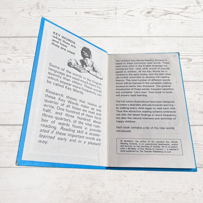 Open book with text and a black and white illustration on a wooden surface
