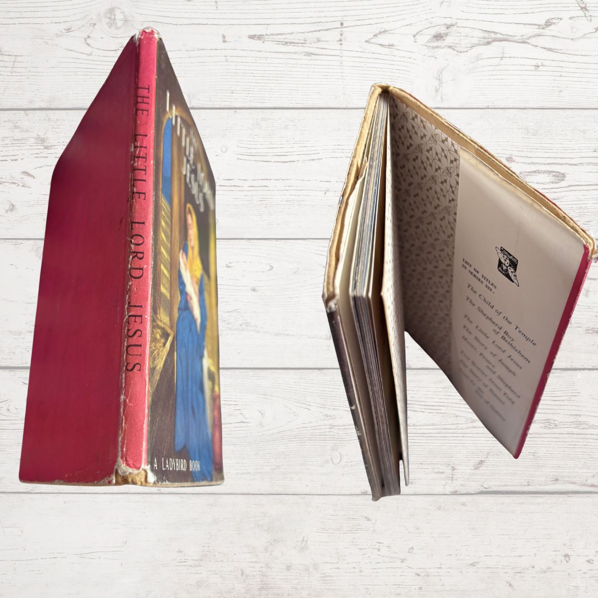 Open book with red binding on a wooden surface