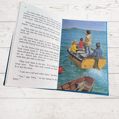 Open book with a page of text and an illustration of children on a boat.