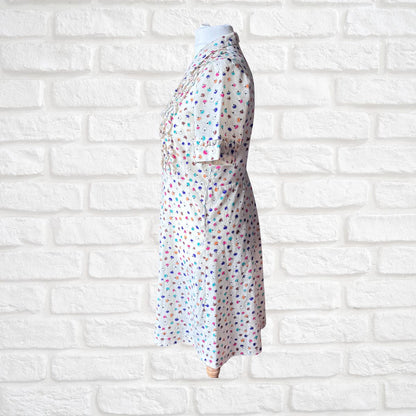 Polka dot dress on a mannequin against a white brick wall background